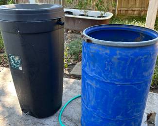Two rain barrels, commercially made in the left and homemade on the right. Blue barrel needs a new spigot 