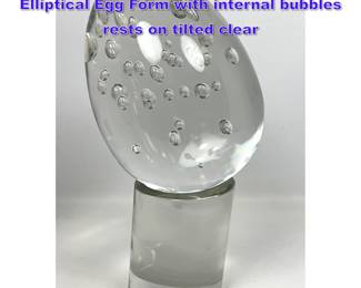 Lot 716 Clear Art Glass Modernist Sculpture. Elliptical Egg Form with internal bubbles rests on tilted clear