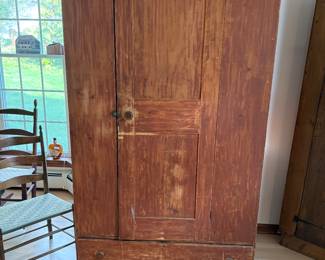 A very early, possibly Shaker per owner, cupboard with drawer in a red wash finish. 
