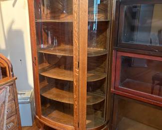 Antique American oak curio cabinet from the turn of the 20th century, curved glass sides, likely quarter-sawn "tiger" oak