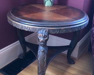 Antique round 3-leg table with carved faces (29” diameter, 26” tall)