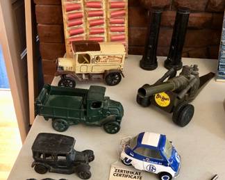 Vintage store display of FAKE firecrackers, cast iron toy trucks, vintage Big Bang toy cannon, Boeing flashlights, vintage curling iron