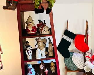 Displayed on a Bittersweet Creations Red Bookshelf Are Numerous Holiday Collectibles Including Gotham, "Father Christmas with Coat" #VFAC-3, Mark Robert's Christmas Fairy (Several Available), A Leonard Hand Blown (Italy) Boy Featuring a Frosted Drummer Boy Handle, Fairfield Folk Art Bulbous Santa Figurines, Snow Babies, Signed Walnut Ridge Primitives Snowmen, Handmade Velvet Stockings and Much More,