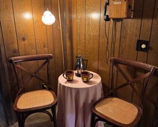 Cozy bistro. 2 classic chairs, small round table, floor lamp, carafe and mugs.