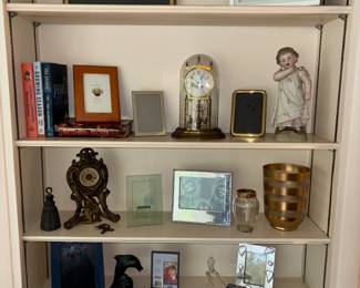 Bookcase items, frames. table top anniversary clocks, books and figurines