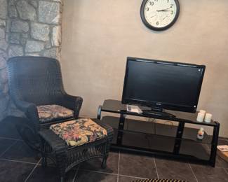 Covered porch or indoor wicker look rocking chair with matching ottoman.  TV, Modern TV stand, Wall clock, Flameless candles