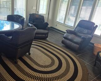 Chair on the right is a leather massage chair, chair by door is leather manual recliner, rug is handwoven braided area rug