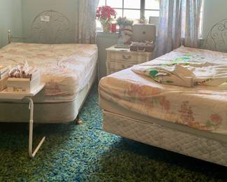 Double beds with metal filigree headboards on frame