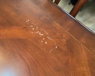 Imperfection on dining table.    It does not appear to be 'scratches' rather something on the surface.  Probably can be buffed out.