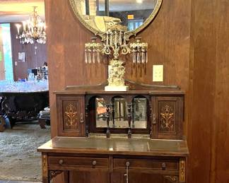 Supporting the candle holder is an elegant secretary's desk.