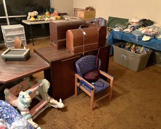 There are three wooden cases in the center of this photo.  At least one says "SINGER" on it.  