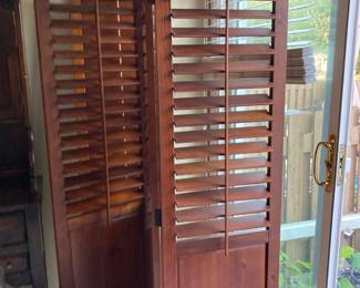 a pair of wood free standing room dividers with shutters