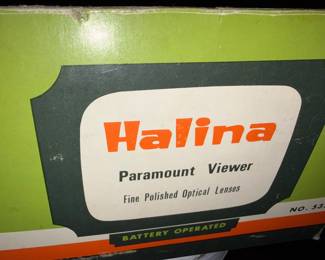 Halina Paramount viewer The Halina slide viewer, which could also function as a "Paramount viewer," was likely made around 1960 or the late 1950s. Its design featured a simple battery-powered light and a magnifying lens for viewing 35mm color slides, reflecting the surge in popularity for this type of photography accessory during that era