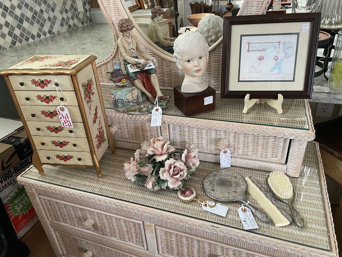 Variety of keepsakes & collectibles on a vintage wicker dresser