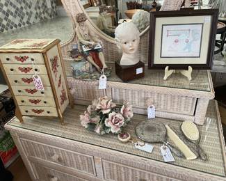 Variety of keepsakes & collectibles on a vintage wicker dresser