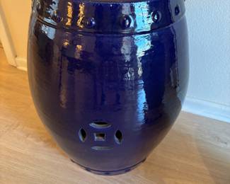 This is a modern ceramic garden stool with a dark blue glaze.