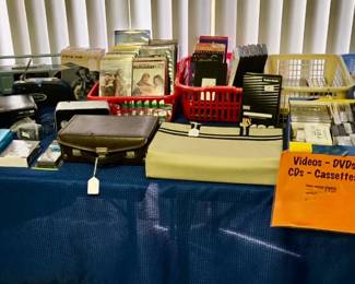 DVDs, CDs, Cassettes, VHS Tapes, Quasar Boombox, Panasonic Lumix Camera, Hand Crank Radio, Hand Held Tape Recorder, Vintage Music Storage, Pelonis Tower Fan in Box and much more