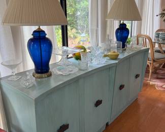 Mint green pair of cabinets, blue glass lamps, various nice glass& pottery pieces on top