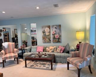 Couch, chairs, coffee table, retro lamps, floral paintings