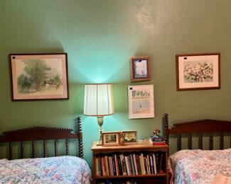 Jenny Lind style spindle twin beds, lots of unique spiritual study books, bookshelf art and brass lamp 