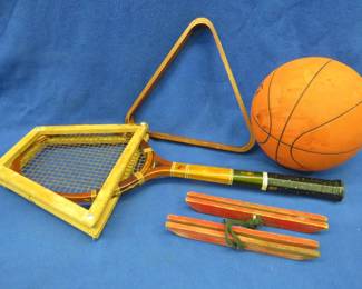 Lot 404. Vintage sporting goods including a Dr. J basketball, wooden pool rack, skate guards, and a tennis racket