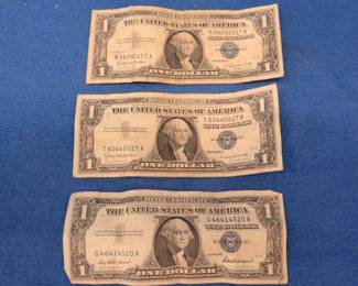 Lot 122. Three 1957 silver certificate one dollar bills