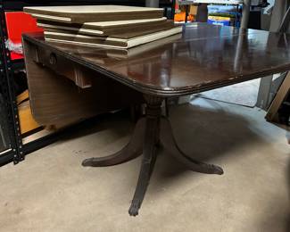 This mahogany brass foot drop leaf table comes with table pads! A beautiful piece and so practical when dining space is limited. This piece is solid and high quality.