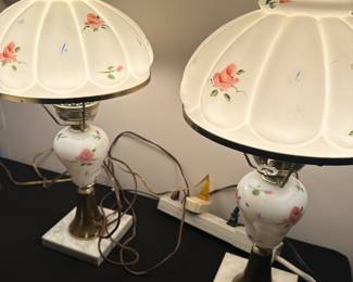 vintage Victorian-style hurricane lamps with floral designs on a marble base