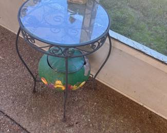 Outdoor side glass-topped table with a wrought-iron base
