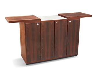 2278
A Modern wood mobile bar cart
Mid-20th century
Unmarked
The sliding expandable top above locking cabinet doors revealing a liquor locker and upper sliding drawer, centering opposed cabinet doors, the left revealing a single shelf and the right revealing three sliding drawers, all raised on casters
Stored: 32" H x 41" W x 14" D; Open: 60.75" W
Estimate: $500 - $700