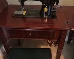 Antique Singer sewing machine in cabinet with stool