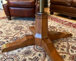 Brass details on Adjustable table with glass top, lowers to be a coffee table, 43” round