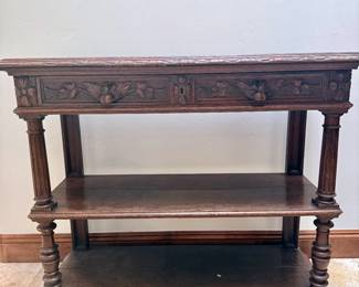 Hand carved Mexican wood shelving unit that is marble topped with arms