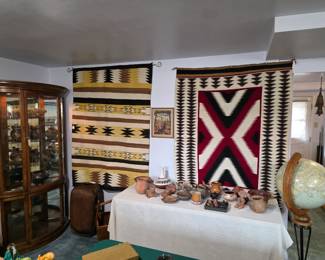 Lower level view. Two Navajo rugs, assorted Native American pottery