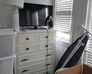 Tall dresser; table lamp; TV; ironing board