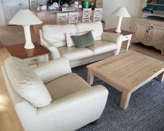 Cream leather sofa with two matching chairs. Two end tables with matching lamps. One coffee table