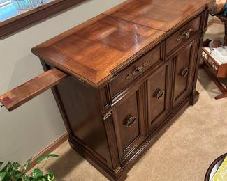 This is a flip-top Henredon serving table. On the left is one of the two slide-outs to support the 'flip top'. 