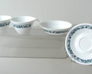 Four pieces of Corelle dishware featuring the Old Town Blue pattern, produced 1974-2017. Two cups, one saucer, one bowl.