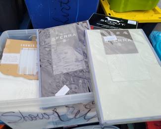 Bin full of brand new shower curtains 