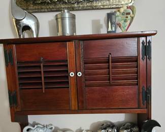 vintage Olga Fisch brass on wood from Ecuador above the wall cabinet with plate shelf
