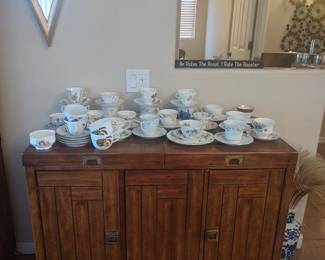 Sideboard with many of the tea cups and saucers
