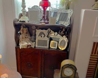 Another cabinet is shown here, with several photo frames and a couple of lamps.