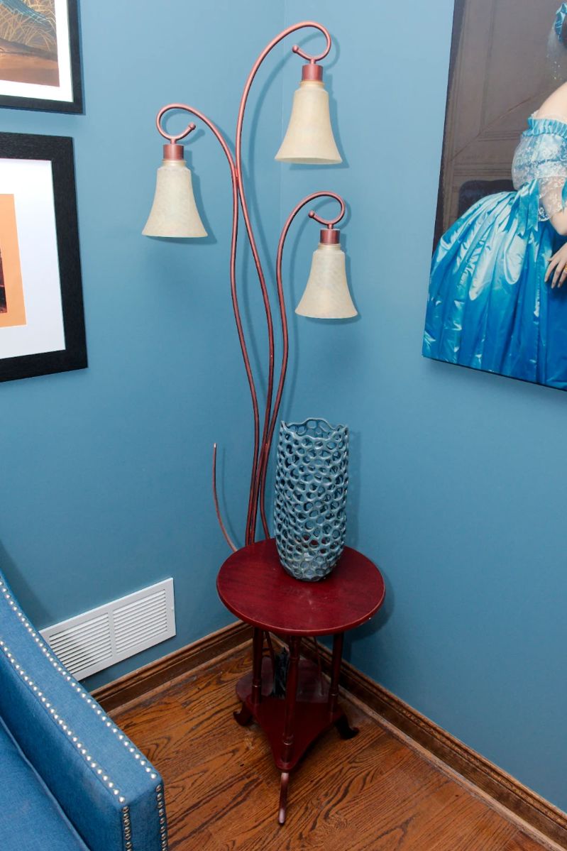 A vintage copper and three-light floor lamp, a Motivo Designs Gabrielle ceramic vase, wooden round top occasional table