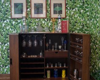 Another view of the fabulous wooden bar cabinet where traditional craftsmanship meets mid-century modern style: Each door features built-in storage for bottles and barware, and the interior with stemware racks, open shelves and drawer box.