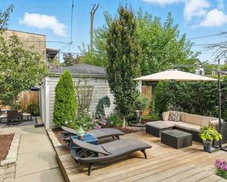 Stylish outdoor furniture available including a set of rattan wicker reclining lounge chairs, coffee table and outdoor couch, with a large outdoor cantilever offset patio umbrella with steel frame and base. The potted plants are available too!