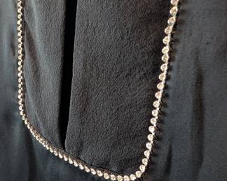 Closeup of R.E.D. Valentino black silk blouse with rhinestone accents, size 46