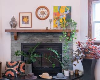 Decorative throw pillows, stylish hats, potted plants, wall clock, framed art