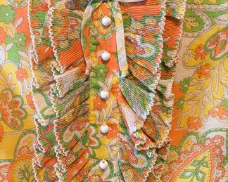 Closeup of the vintage 1970s Bobbie Brooks orange, yellow and green paisley print long sleeve mini dress