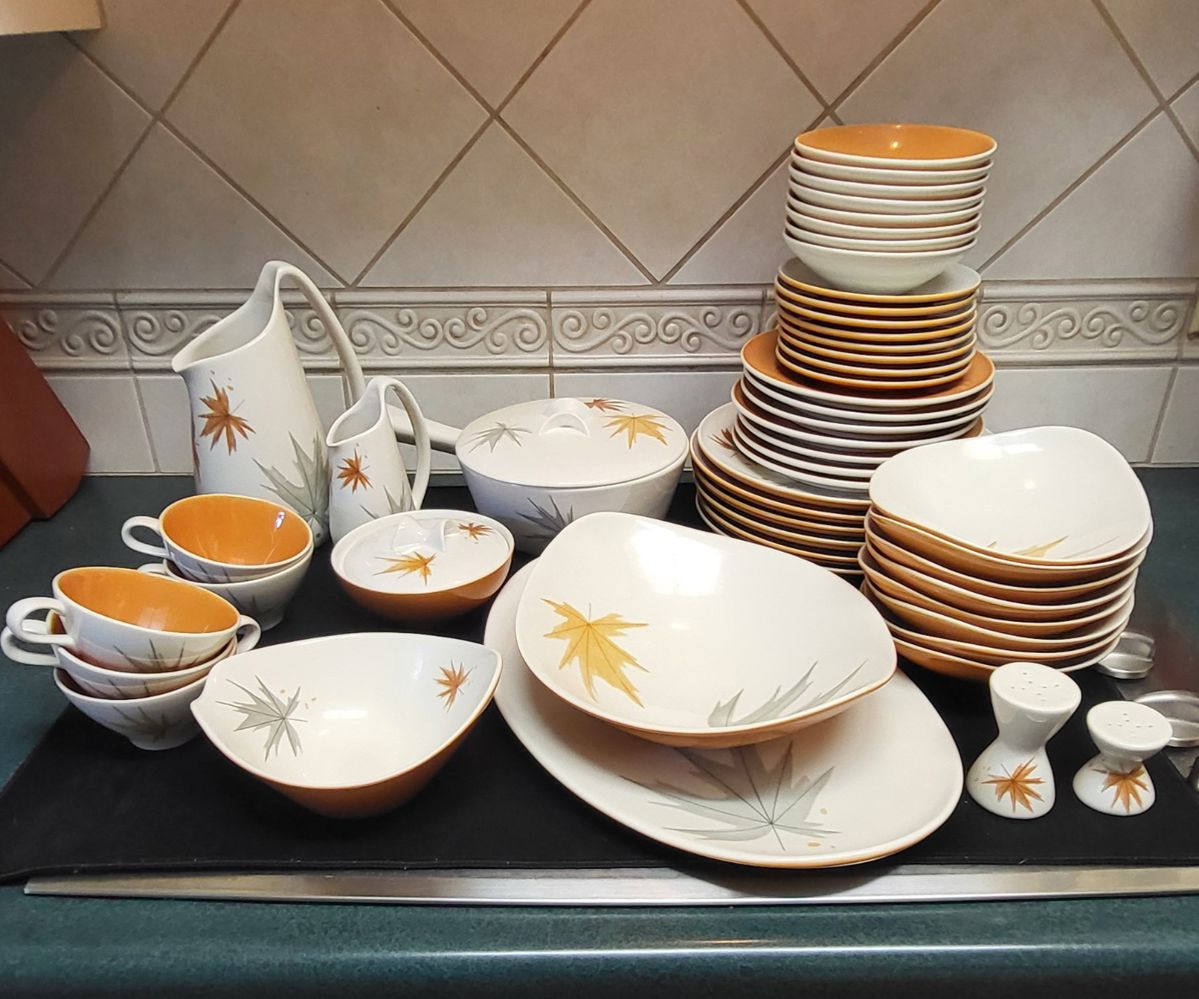 The dinnerware set shown is the Harvest Time pattern, designed by Ben Seibel for Iroquois China. The pattern, also known as "Autumn Leaf," was manufactured between 1958 and 1969.