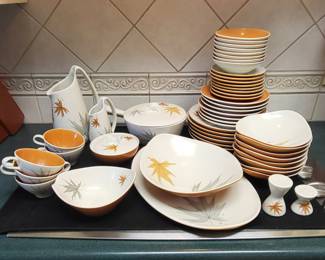 The dinnerware set shown is the Harvest Time pattern, designed by Ben Seibel for Iroquois China. The pattern, also known as "Autumn Leaf," was manufactured between 1958 and 1969.